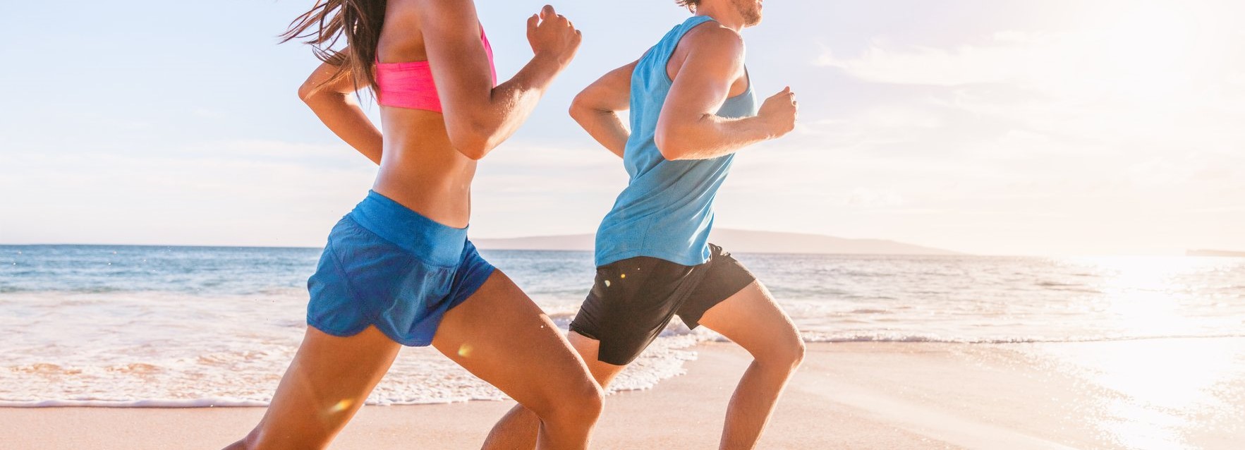 Run fit people running on beach with healthy toned legs body, Hamstring muscles, knee joint health active lifestyle panoramic banner background.